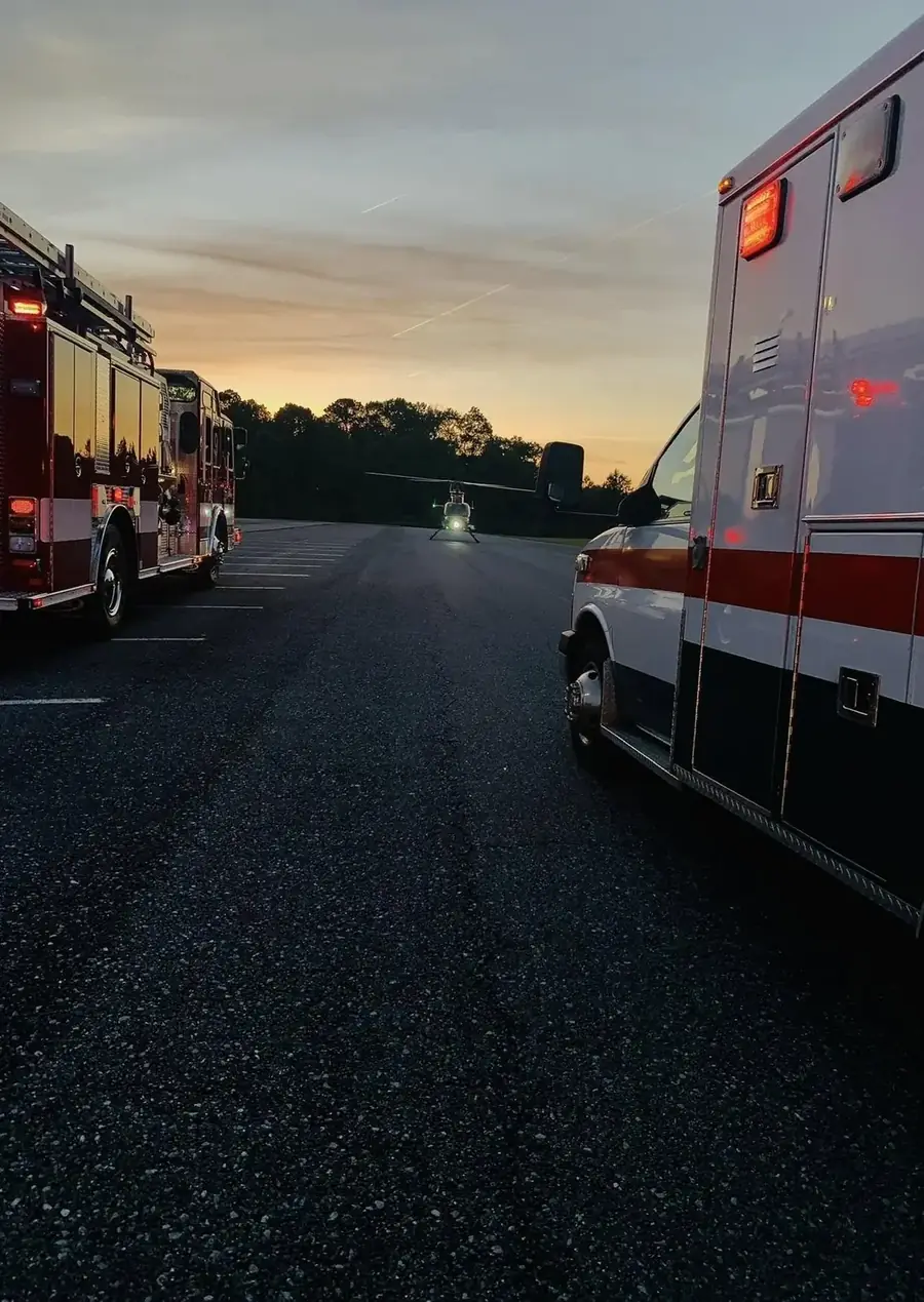Fire truck, ambulance, and a medical helicopter staged at dusk